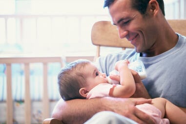 dad feeding baby bottle